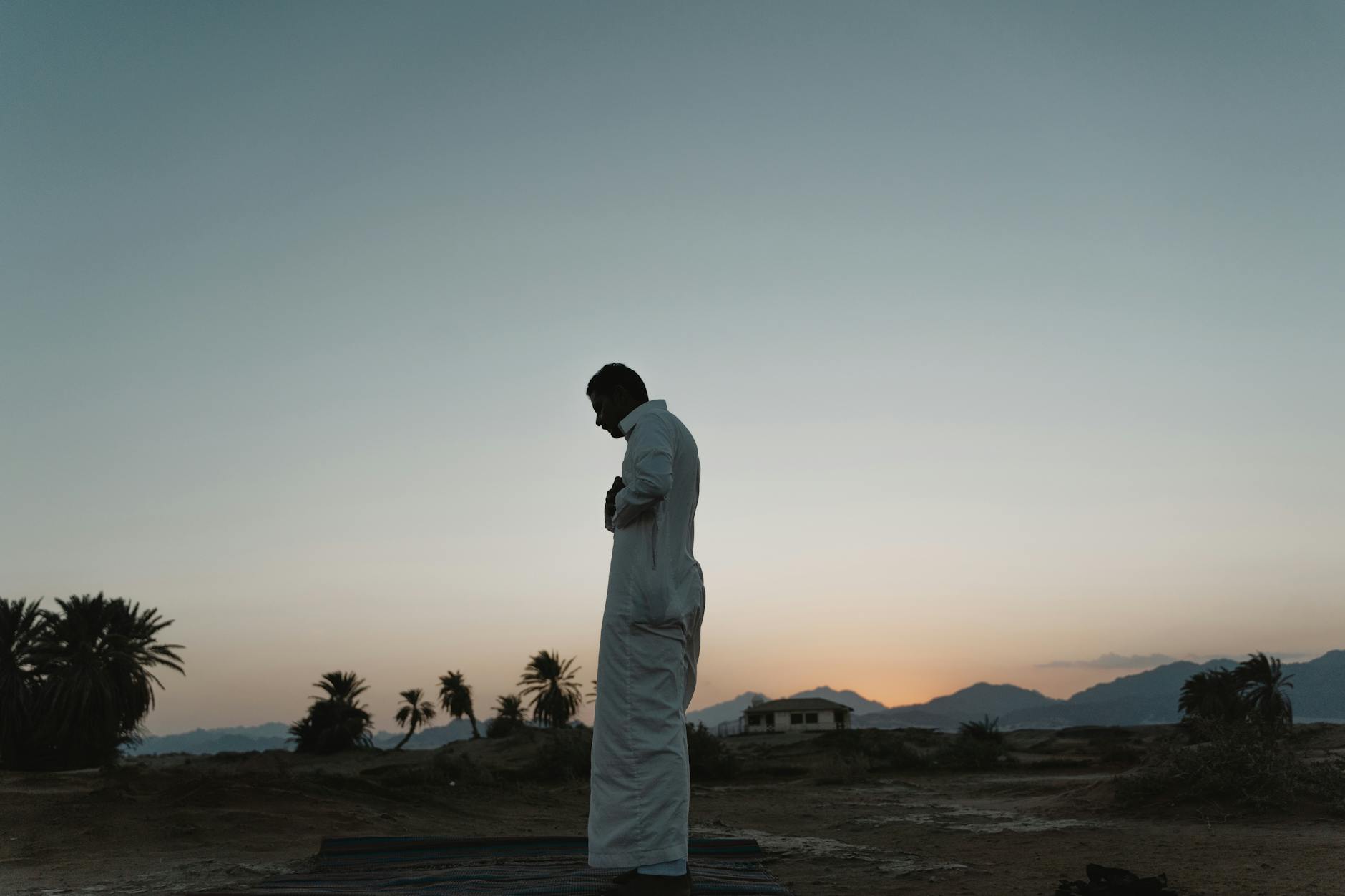 Person praying at sunrise representing commitment to biblical financial principles